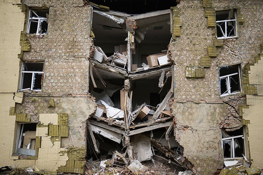 Debris hangs from a residential building after Russian bombardment in Bakhmut, Ukraine.