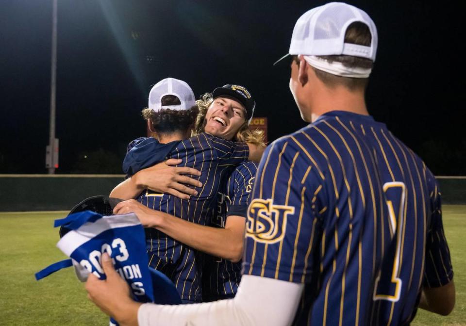 Sutter Huskies senior Matt McCall (2), center, hugs teammate and relief pitcher Logan Yacavace (4) while Rylan Giovannoni (1) holds the CIF Sac-Joaquin Section Division V high school baseball title Tuesday, May 23, 2023, after their 4-3 extra-innings win over Bradshaw Christian.