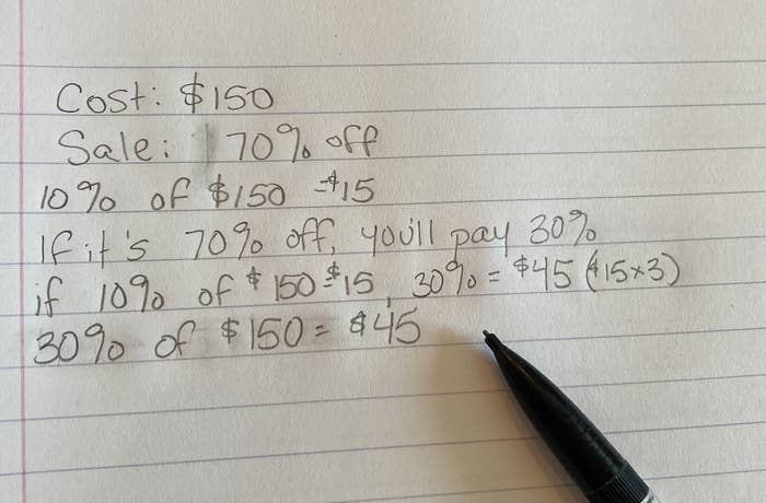 Handwritten math calculations showing a discount problem, with a pen resting on the paper