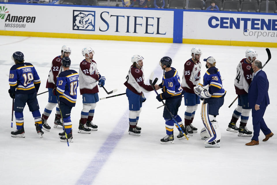 Members of the Colorado Avalanche and St. Louis Blues shake hands following Game 4 of an NHL hockey Stanley Cup first-round playoff series Sunday, May 23, 2021, in St. Louis. Colorado won the game 5-2 to take the series 4-0. (AP Photo/Jeff Roberson)