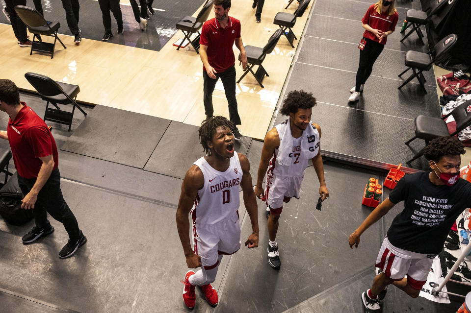 FILE - In this Saturday, Feb. 20, 2021 file photo, Washington State center Efe Abogidi, centre, celebrates alongside guard Myles Warren (2) after beating Stanford, in an NCAA college basketball game, in Pullman, Wash. A serious knee injury nearly ended Efe Abogidi's basketball career but he's now back on the NBA draft radar. The 19-year-old Nigerian is known for his high-flying dunks and plays for Washington State in the Pac-12. But his journey from West Africa to the West Coast was atypical with stops in Senegal and Australia. (AP Photo/Pete Caster,File)