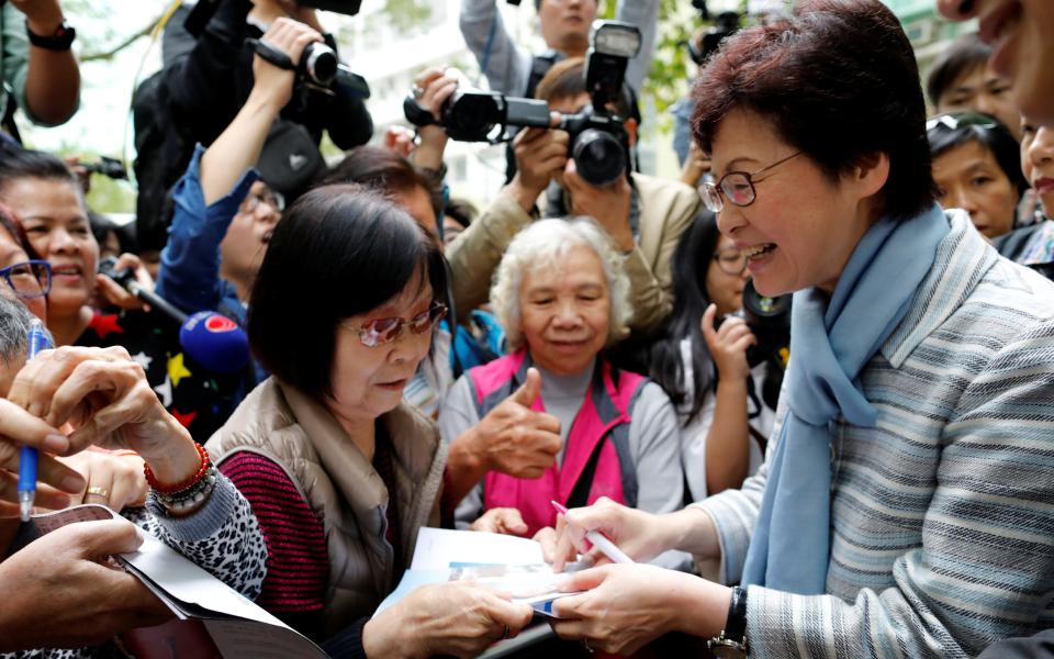 Chief Executive election candidate Carrie Lam signs autographs - Credit: Reuters