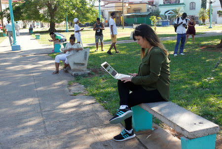 Elaine Diaz, who founded web-based outlet Periodismo de Barrio in 2015, connects to the internet at a hotspot at a park, in Havana, Cuba February 5, 2018. REUTERS/Stringer