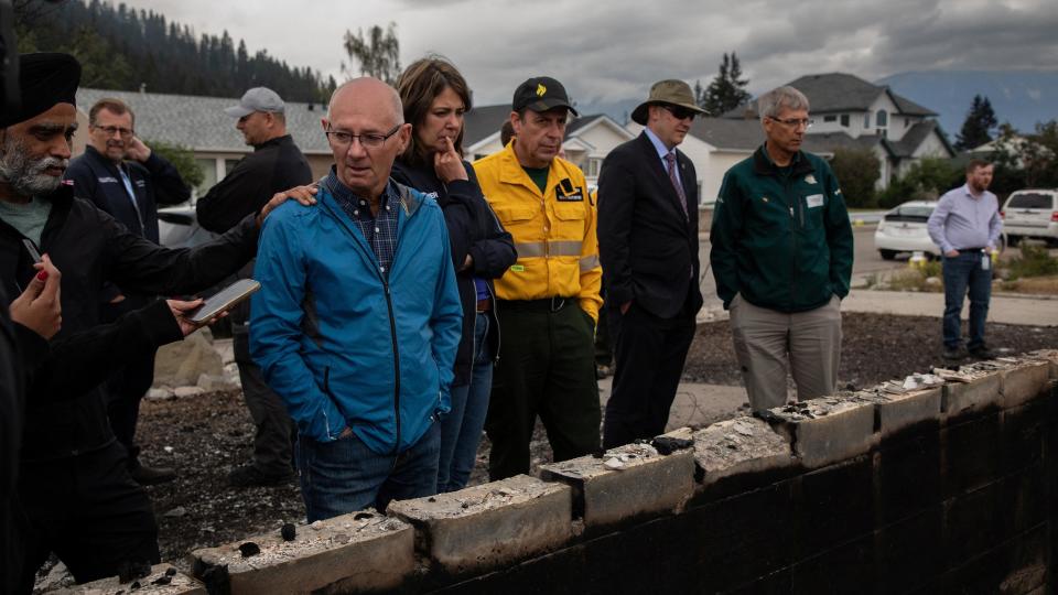 Jasper Mayor Richard Ireland, looks at what is left of his home of 67 years with federal Minister of Emergency Preparedness Harjit Sajjan, Premier Danielle Smith, and Minister of Forestry and Parks Todd Loewen in Jasper, Alberta, Canada, on Friday, July 26, 2024. AMBER BRACKEN/Pool via REUTERS