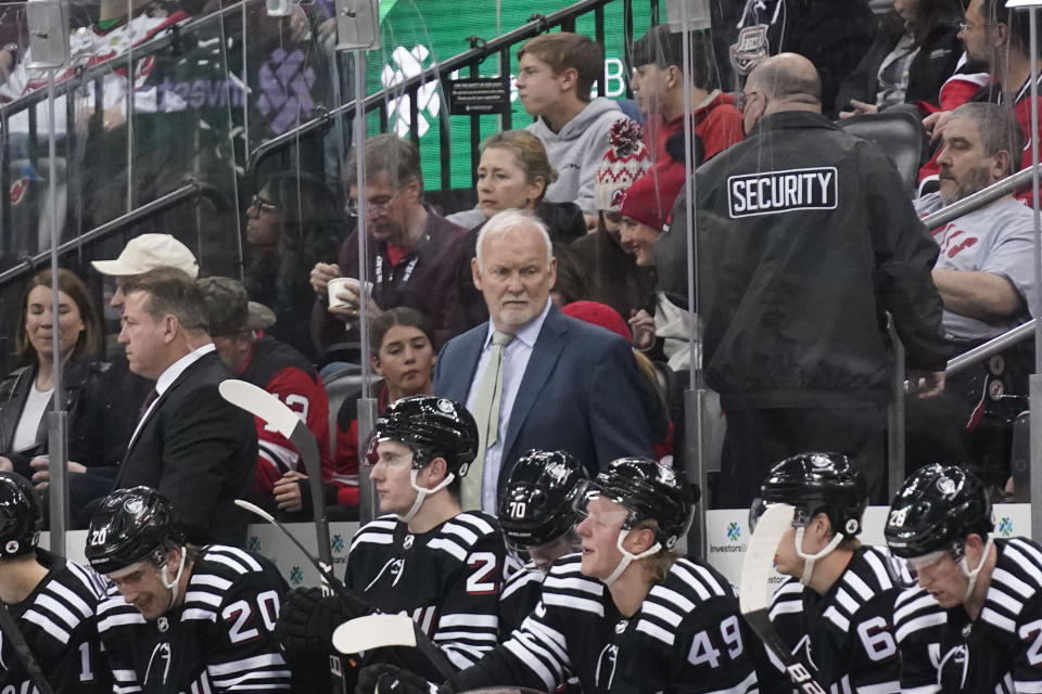 New Jersey Devils head coach Lindy Ruff, center, looks over the ice during the second period of an NHL hockey game against the Detroit Red Wings in Newark, N.J., Friday, April 29, 2022. (AP Photo/Seth Wenig)