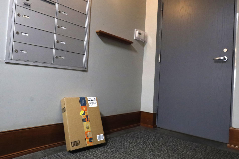 An Amazon package sits by the mailbox at Jason Goldberg's apartment, Monday, March 29, 2021, in Chicago. Amazon is making a push to install a device on buzzer systems in apartment buildings throughout the country that allows its delivery drivers to whip out a phone, tap a button and unlock a building's front doors whenever they need to leave packages in the lobby instead of the street. (AP Photo/Shafkat Anowar)