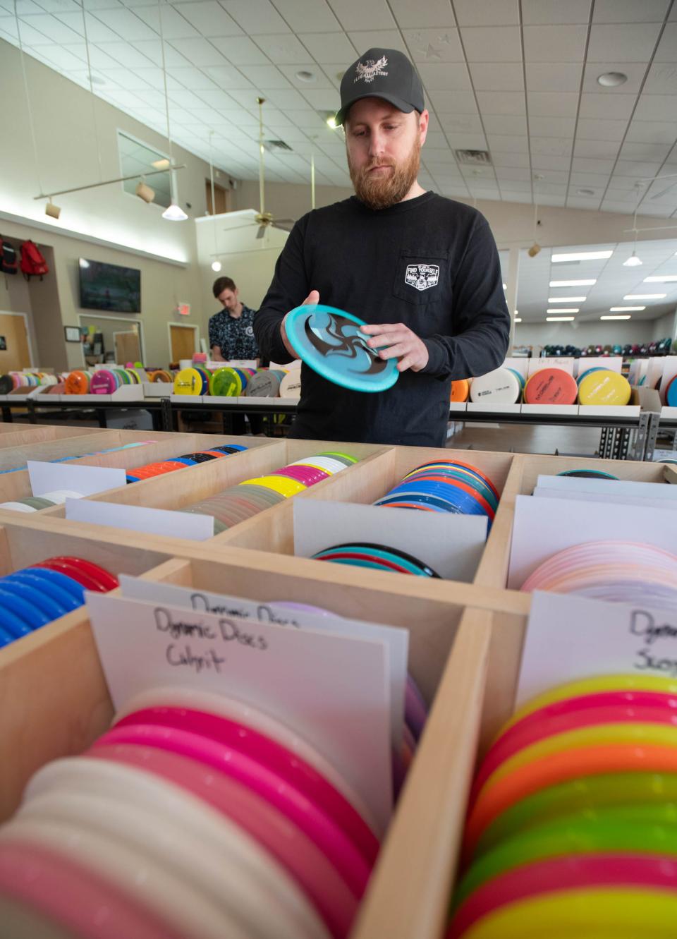 Emerald Coast Disc Golf Club officer Ryan Vann sorts discs at Flight Factory Discs in Pensacola on Monday, Dec. 18, 2023. ECDGC is preparing for the 2024 Gold Rush tournament that will be held in January.