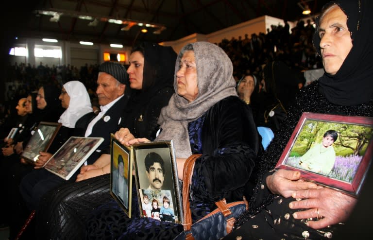 Iraqis Kurds hold pictures of deceased relatives as they gather in Halabja on March 16, 2018, to mark the 30th anniversary of an infamous gas attack by Saddam Hussein's forces that killed some 5,000 people