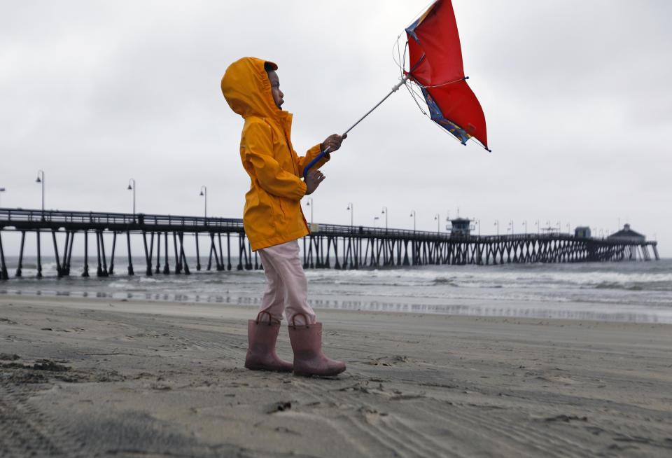 Reagan King battles the wind while out with her parents at Imperial Beach after the eye of Tropical Storm Hilary passed on Sunday, Aug. 20, 2023, in San Diego. The Imperial Beach Pier was closed to the public. (K.C. Alfred/The San Diego Union-Tribune via AP)