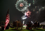 FILE - In this July 4, 2013, file photo, people watch as fireworks explode overhead during the Fourth of July celebration at Pioneer Park in Prescott, Ariz. For many Americans, the Fourth of July won't be about big festivities but setting off fireworks themselves. Hundreds of cities have canceled shows Saturday because of the coronavirus pandemic, and sales of consumer fireworks are booming. (AP Photo/Julie Jacobson, File)