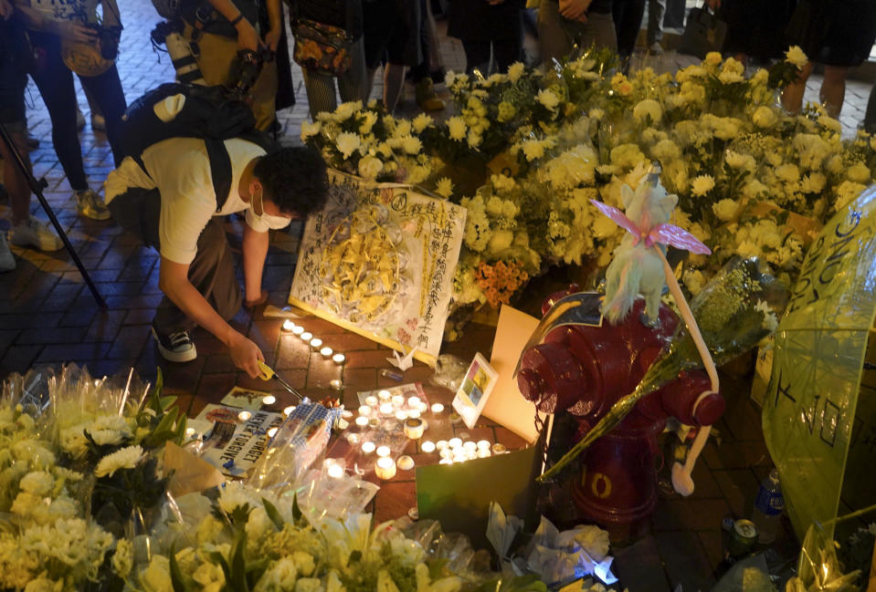 Mourners lay flowers as they pay respect on the site to mark the one year anniversary where a man fell to his death after hanging a protest banner against the extradition bill on a building scaffolding in Hong Kong Monday, June 15, 2020. Protesters in Hong Kong got the government to withdraw extradition legislation last year, but now they're getting a more dreaded national security law, and the message from Beijing is that protest is futile. (AP Photo/Vincent Yu)