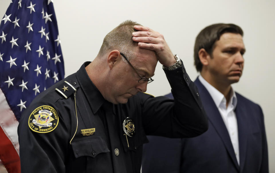 Sebring Police Chief Karl Hoglund wipes his head as he listens to Florida Gov. Ron DeSantis speak during a news conference, Wednesday, Jan. 23, 2019, in Sebring, Fla., after authorities said five people were shot and killed at a SunTrust bank branch. (AP Photo/Chris O'Meara)