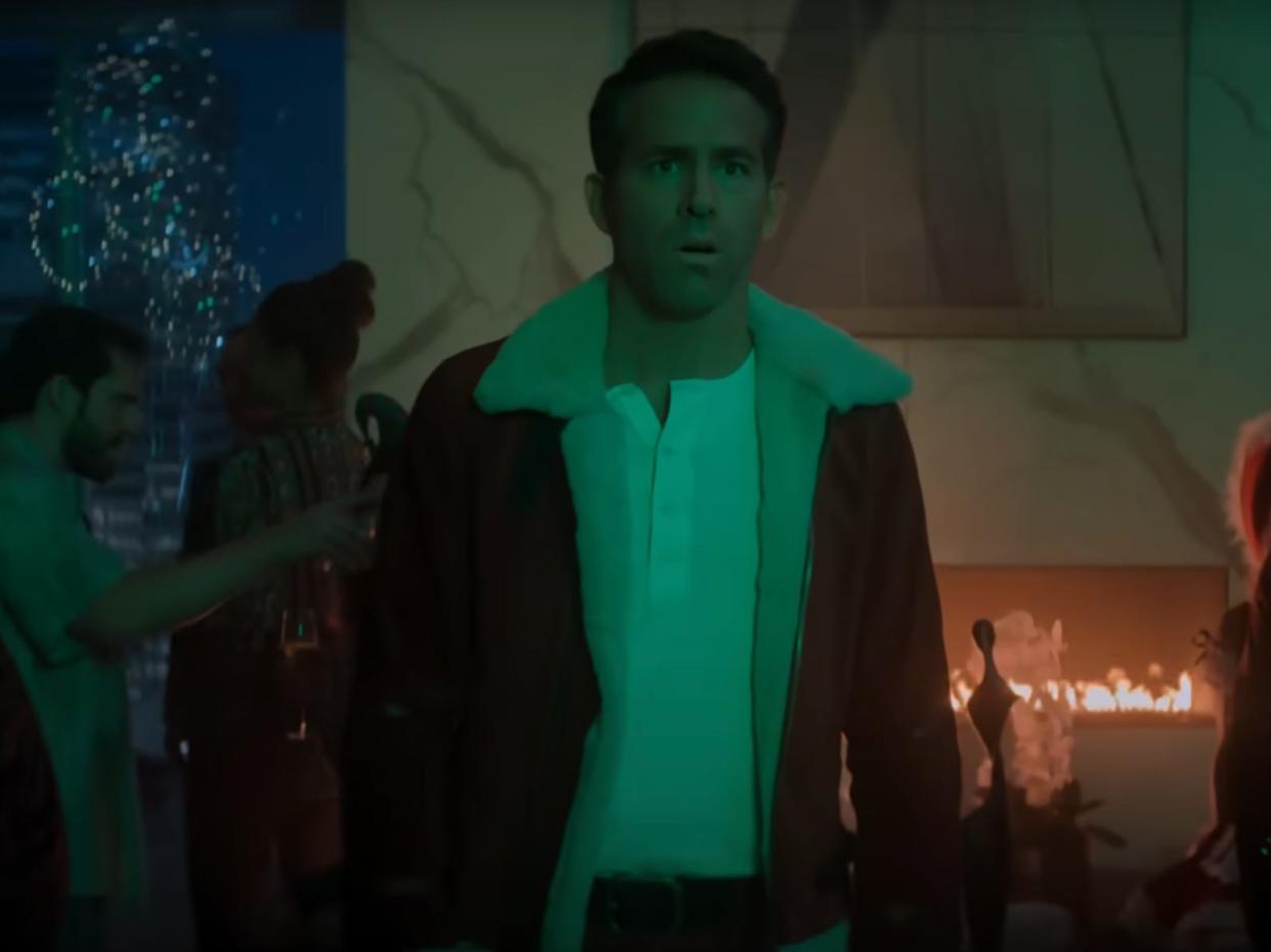 Ryan Reynolds in a darkly-lit room in "Spirited."