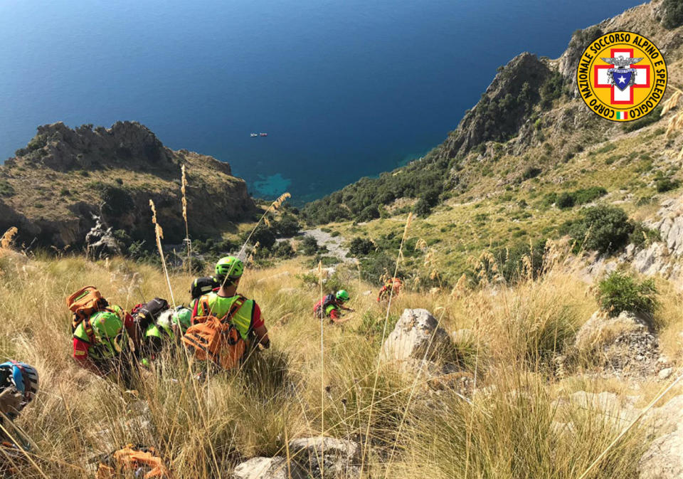 Members of the Italian mountain rescue team search for a French hiker in the Cilento region, Southern Italy, Monday, Aug. 19, 2019. Italian mountain rescue squads have recovered the body of a French hiker who fell into a ravine and broke his leg. Nine days of search ended Sunday when alpine rescue spotted Simon Gautier’s backpack and then his body in a ravine in the Cilento region of Southern Italy. Crews were able to recover the body Monday. (Corpo Nazionale Soccorso Alpino e Speleologico via AP)