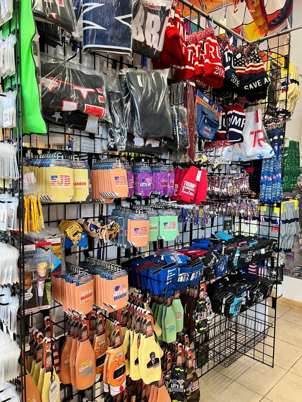 A wall of can koozies and hats.