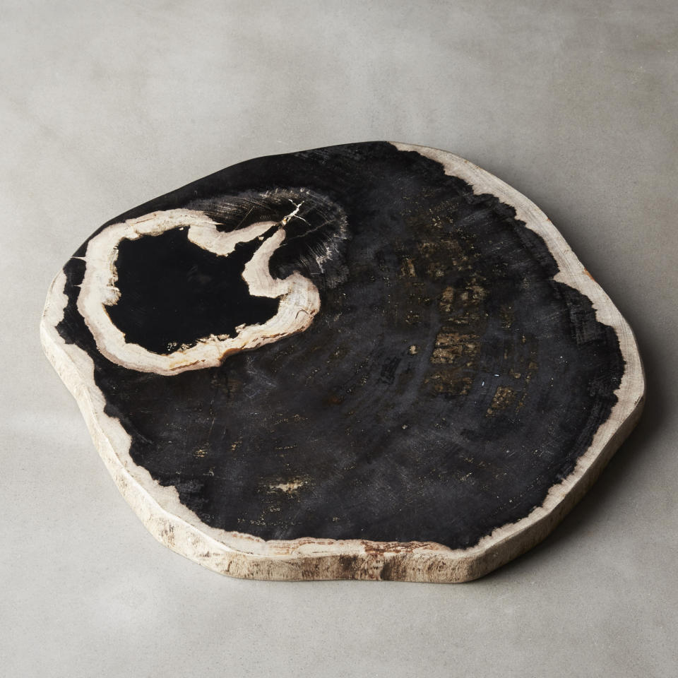 This photo provided by CB2 shows one of their petrified wood serving boards. (CB2 via AP)