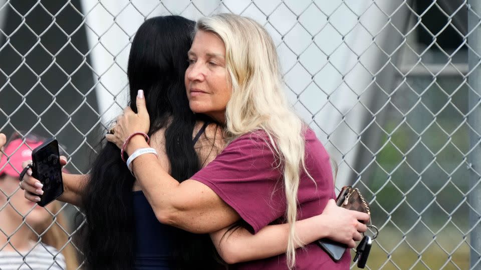 Joanne Wallace, right, former special education teacher at Marjory Stoneman Douglas High School, hugs an onlooker during the demolition. - Wilfredo Lee/AP