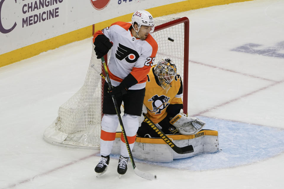 A shot by Philadelphia Flyers' Sean Couturier gets by Pittsburgh Penguins goaltender Tristan Jarry (35) for a goal as James van Riemsdyk (25) crowds the crease during the first period of an NHL hockey game Thursday, March 4, 2021, in Pittsburgh. (AP Photo/Keith Srakocic)