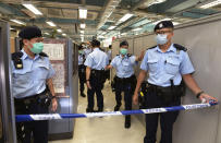 Police officers set up cordon line inside the Apple Daily newspaper headquarters after Hong Kong media tycoon and newspaper founder Jimmy Lai was arrested at his home in Hong Kong, Monday, Aug. 10, 2020. Hong Kong police arrested Lai and raided the publisher's headquarters Monday in the highest-profile use yet of the new national security law Beijing imposed on the city after protests last year. (Apple Daily via AP)