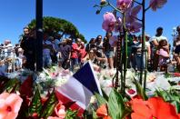 Members of the public lay flowers at a make-shift memorial site on July 15, 2016 in Nice, in tribute to victims of the deadly Bastille Day attack