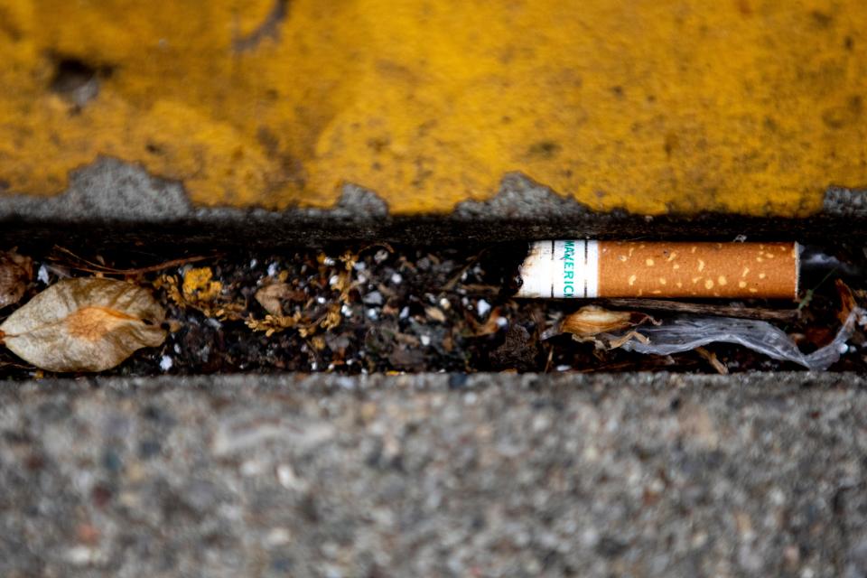 A Maverick menthol cigarette butt rests on the ground. More teens who smoke are turning to menthol because it causes less throat irritation and cough that non-menthol cigarettes.