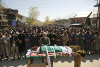 Kashmiri villagers offer prayers during the funeral of Umer Farooq, a Kashmiri civilian who was killed Sunday at Baroosa village 34 Kilometers (21 miles) northeast of Srinagar, Indian controlled Kashmir, Monday, April 10, 2017. Government forces opened fire on Sunday on crowds of people who attacked polling stations during a by-election for a vacant seat in India's Parliament, killing eight people. (AP Photo/Mukhtar Khan)