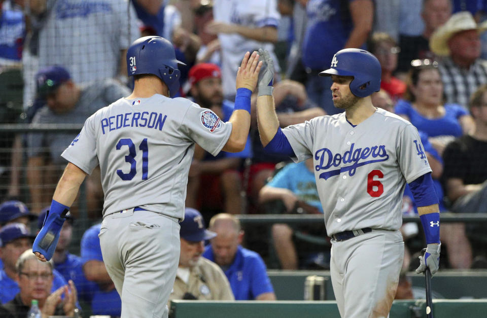 Los Angeles Dodgers’ Joc Pederson (L) high fives Brian Dozier after scoring against the Texas Rangers in the third inning of a baseball game Tuesday, Aug. 28, 2018, in Arlington, Texas. (AP Photo)