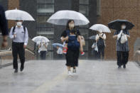 People make their way in a rain affected by a tropical storm in Sendai, Miyagi prefecture, northeast of Tokyo Wednesday, July 28, 2021. Nepartak, the season's eighth typhoon for Japan, brought strong winds and heavy rain to Japan's northern coast Wednesday after moving away from the Tokyo region and relieving the Olympic host city of a feared disruption to the games. (Kyodo News via AP)