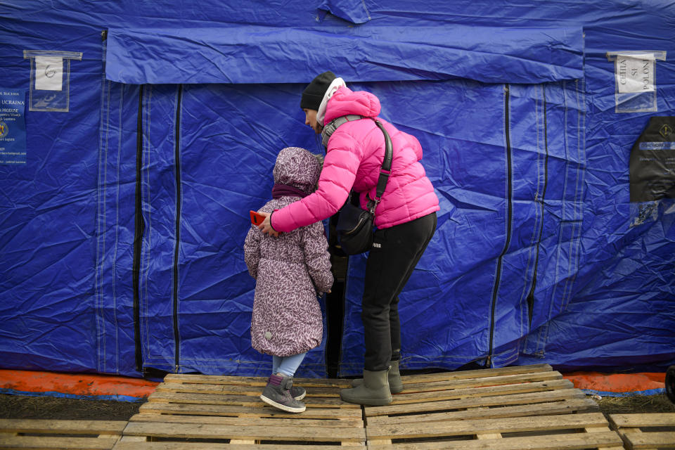 A refugee fleeing the conflict from neighbouring Ukraine enters a tent at the Romanian-Ukrainian border, in Siret, Romania, Saturday, March 5, 2022. (AP Photo/Andreea Alexandru)