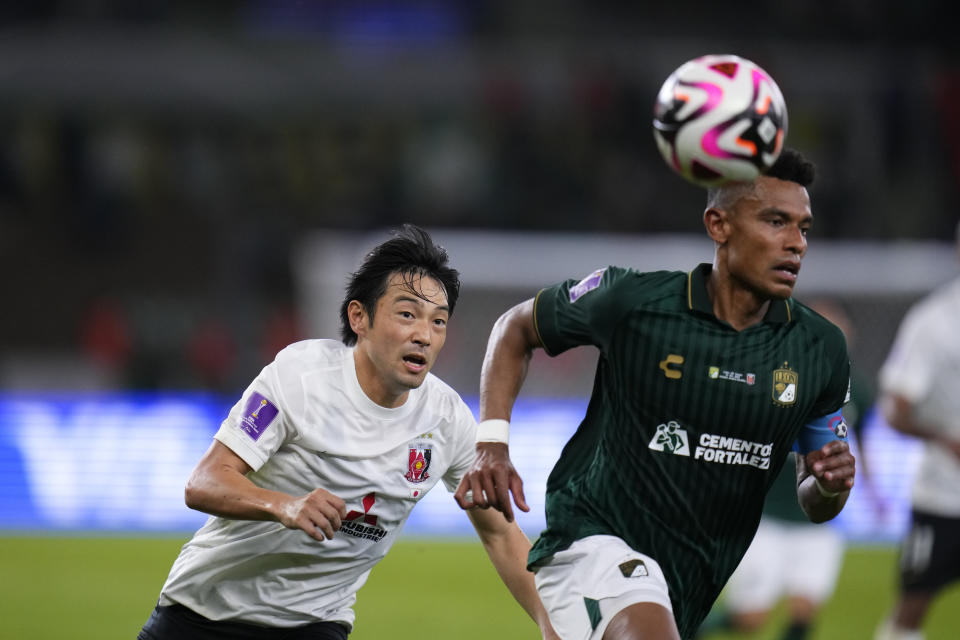 Urawa Reds' Shoya Nakajima, left, and Leon's William Tesillos go for the ball during the Soccer Club World Cup second round soccer match between Club Leon and Urawa Reds at Prince Abdullah Al-Faisal Stadium in Jeddah, Saudi Arabia, Friday, Dec. 15, 2023. (AP Photo/Manu Fernandez)