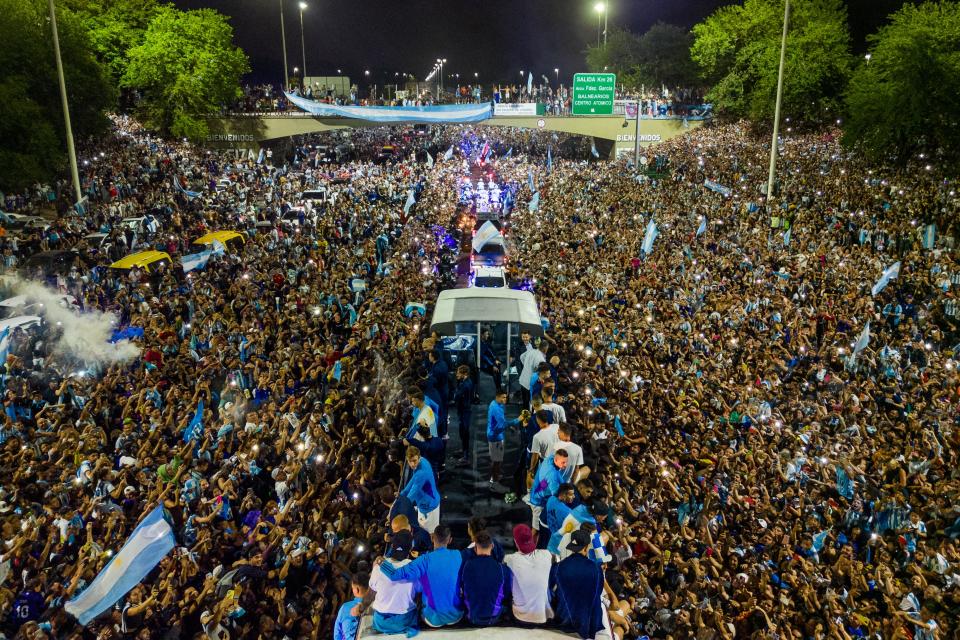 Argentina's players celebrate on board a bus with supporters after winning the Qatar 2022 World Cup tournament as they leave Ezeiza International Airport en route to the Argentine Football Association (AFA) training centre in Ezeiza, Buenos Aires province, Argentina on December 20, 2022. (Photo by Tomas CUESTA / AFP) (Photo by TOMAS CUESTA/AFP via Getty Images)