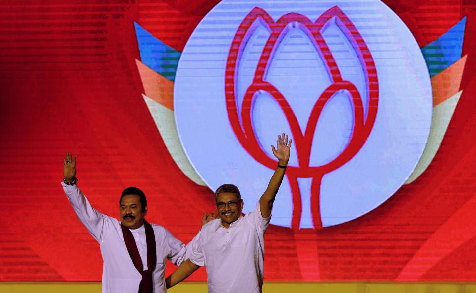 Former Sri Lankan president Mahinda Rajapaksa, left, and former Defense Secretary and his brother Gotabaya Rajapaksa wave to supporters during a party convention held to announce the presidential candidacy in Colombo, Sri Lanka, Sunday, Aug. 11, 2019. Nandasena Gotabaya Rajapaksa, who was a livewire in Sri Lanka's military campaign to end a long civil war but faces allegations of human rights violations, has been nominated as the opposition's candidate for the presidential election scheduled for later this year. (AP Photo/Eranga Jayawardena)