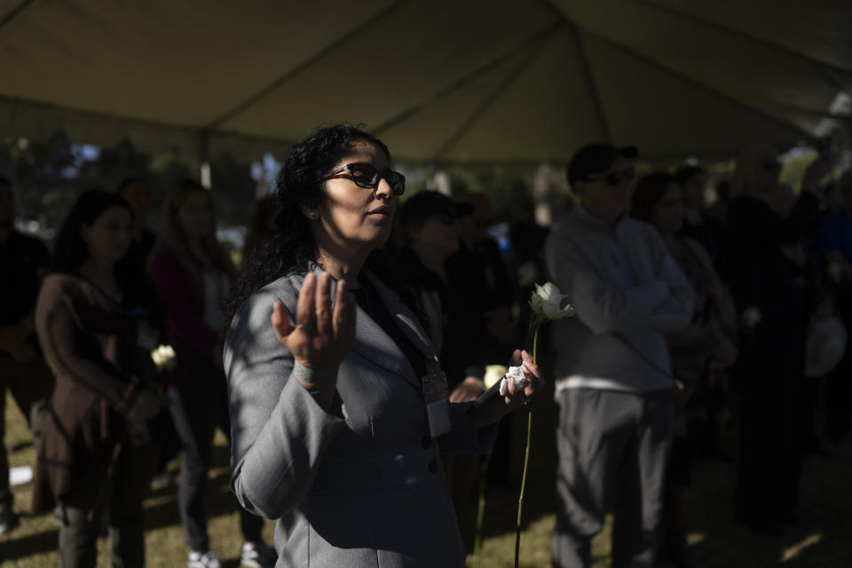 Los Angeles County employee Rosa Gonzalez prays along with other community members during the Los Angeles County ceremony of the unclaimed dead at a county cemetery in Los Angeles, Thursday, Dec. 14, 2023. This year's service laid to rest 1,937 people who died unclaimed in 2020. They were immigrants, children, people experiencing homelessness or poverty, and, for the first time, victims of the coronavirus. (AP Photo/Jae C. Hong)