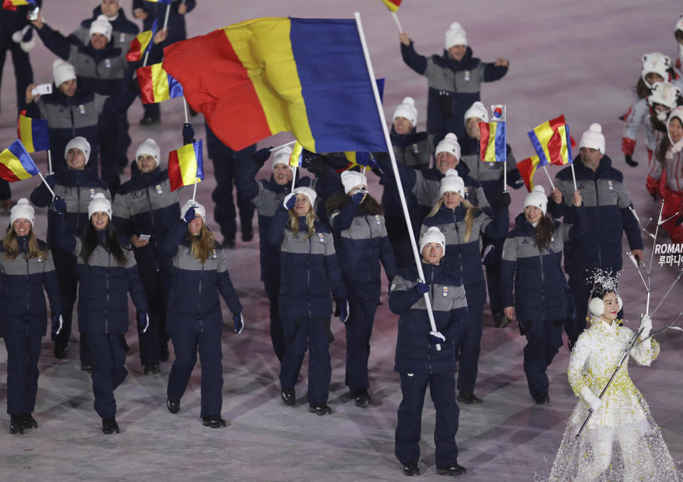 <p>Marius Ungureanu carries the flag of Romania during the opening ceremony of the 2018 Winter Olympics in Pyeongchang, South Korea, Friday, Feb. 9, 2018. (AP Photo/Michael Sohn) </p>