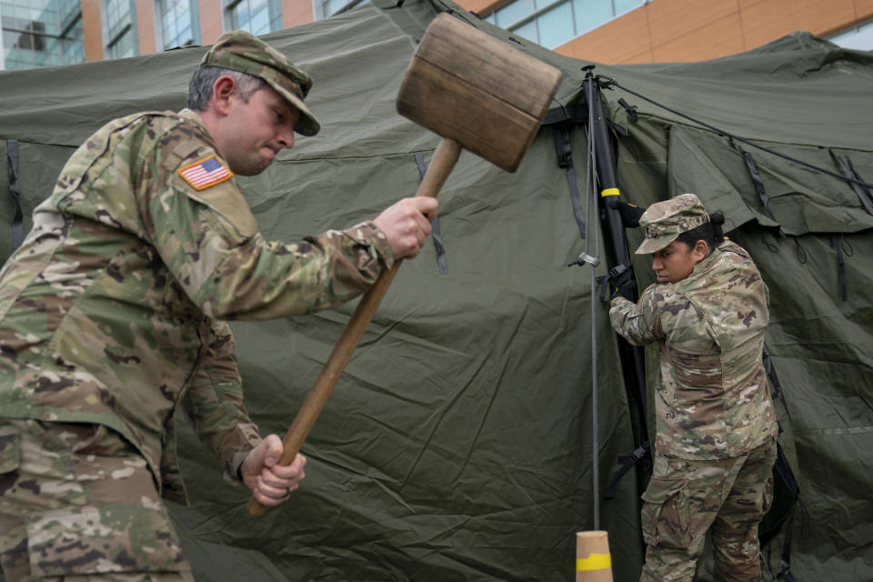 SILVER SPRING, MD - MARCH 19:  Members of the Maryland Army National Guard work to set up a triage tent in the parking lot outside of the emergency room at Adventist HealthCare White Oak Medical Center on March 19, 2020 in Silver Spring, Maryland. Hospitals across the country are preparing for an influx of additional patients due to the COVID-19 pandemic. (Photo by Drew Angerer/Getty Images)