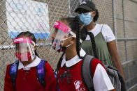 FILE - In this Sept. 9, 2020, file photo, students wear protective masks as they arrive for classes at the Immaculate Conception School while observing COVID-19 prevention protocols in The Bronx borough of New York. The pandemic began with devastation in the New York City area, and was followed by a summertime crisis in the Sun Belt. But it is now striking cities with much smaller populations, often in conservative corners of America where anti-mask sentiment runs high, creating problems at hospitals and schools in the Midwest and West. (AP Photo/John Minchillo, File)