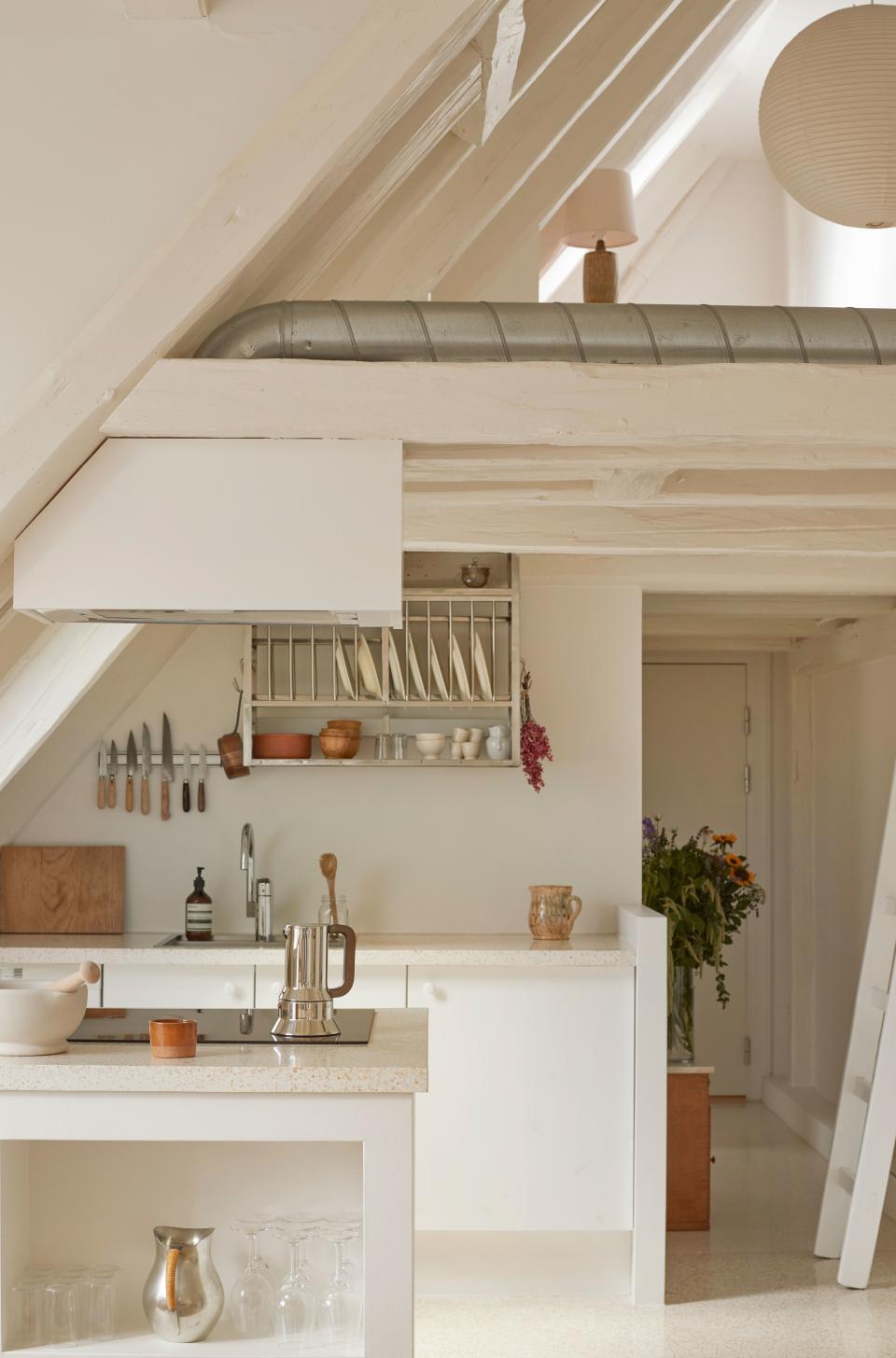 The kitchen is where designer Caroline Feiffer spends quite a lot of time in her home in Old Copenhagen. At top right, a glimpse of the lofted office. The height of the ceilings makes for a feeling of airy spaciousness, as well as a connectivity between the rooms.