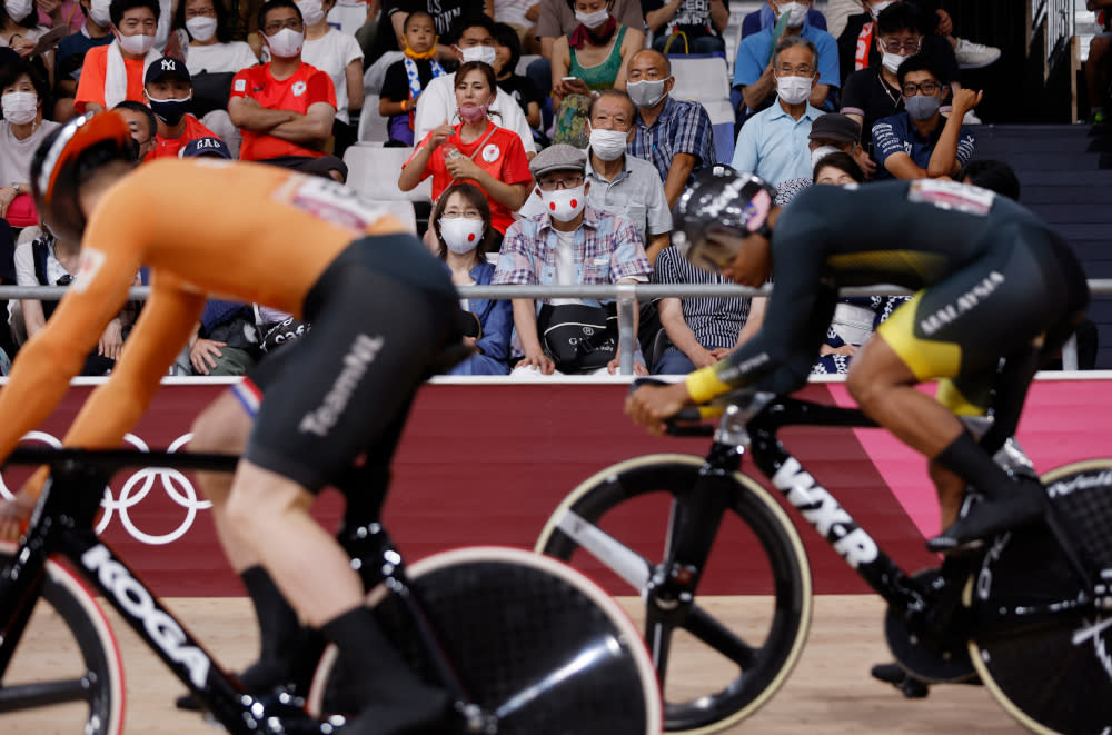 Spectators wearing face masks watch Netherlands’ Harrie Lavreysen and Malaysia’s Muhammad Shah Firdaus Sahrom as they compete in a heat of the men’s track cycling sprint 1/32 finals during the Tokyo 2020 Olympic Games at Izu Velodrome in Izu, Japan, August 4, 2021. — AFP pic
