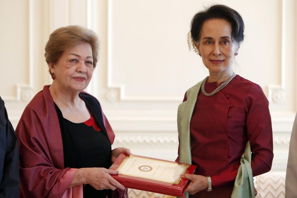 FILE - In this Jan. 20, 2020, file photo, Myanmar's leader Aung San Suu Kyi, right, receives a final report from Philippine diplomat Rosario Manalo, a member of the Independent Commission of Enquiry for Rakhine State, at the Presidential Palace in Naypyitaw, Myanmar. When Suu Kyi walked into the International Court of Justice in December, 2019, she gambled the remaining shreds of her hard-won international reputation on a rebuttal of accusations that her country's military committed genocide against minority Rohingya Muslims. (AP Photo/Aung Shine Oo, File)