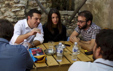 Former Greek prime minister and leader of leftist Syriza party Alexis Tsipras (L) speaks with Syriza youth members at a tavern in the center of Athens, Greece, September 19, 2015. REUTERS/Paul Hanna