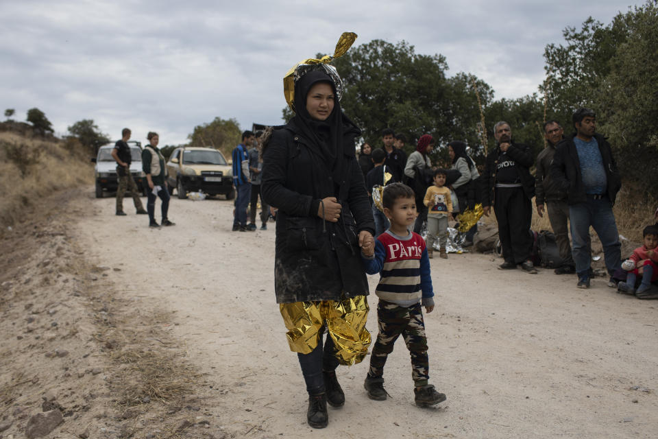 An Afghan woman with her child after arriving with other migrants and refugees after crossing a part of the Aegean Sea, from Turkey to Greece on an overcrowded dinghy, near the town of Madamados on the Greek island of Lesbos, on Monday, Oct. 7, 2019. Authorities in Greece have expanded a program to transfer migrants and refugees from overcrowded camps on the islands to the mainland amid concern that the number of arrivals from nearby Turkey could continue to rise. (AP Photo/Petros Giannakouris)