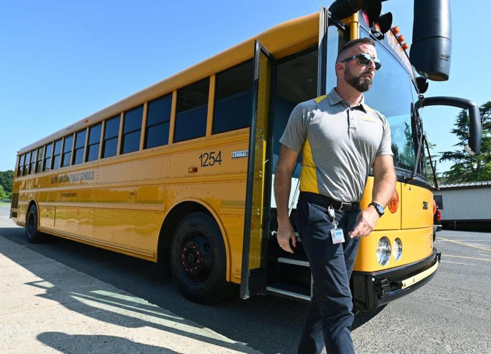 Adam Johnson, the CMS Executive Director of Transportation, exits a bus at South Mecklenburg High School on Wednesday, July 26, 2023. CMS is offering a new bus stop plan, Express Stops, being rolled out this year that is designed to cut down on two-hour ride times and costs to the district.