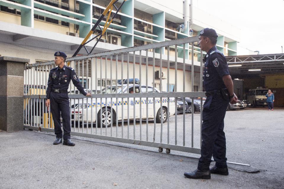 Malaysian police officers guard the gate of the forensic department at Kuala Lumpur Hospital in Kuala Lumpur, Malaysia, Monday, Feb. 20, 2017. Investigators are looking for four North Korean men who flew out of Malaysia the same day Kim Jong Nam, the North Korean ruler's outcast half brother, apparently was poisoned at an airport in Kuala Lumpur, Malaysian police said Sunday. Since Kim's death last week, authorities have been trying to piece together details of what appeared to be an assassination. (AP Photo/Alexandra Radu)