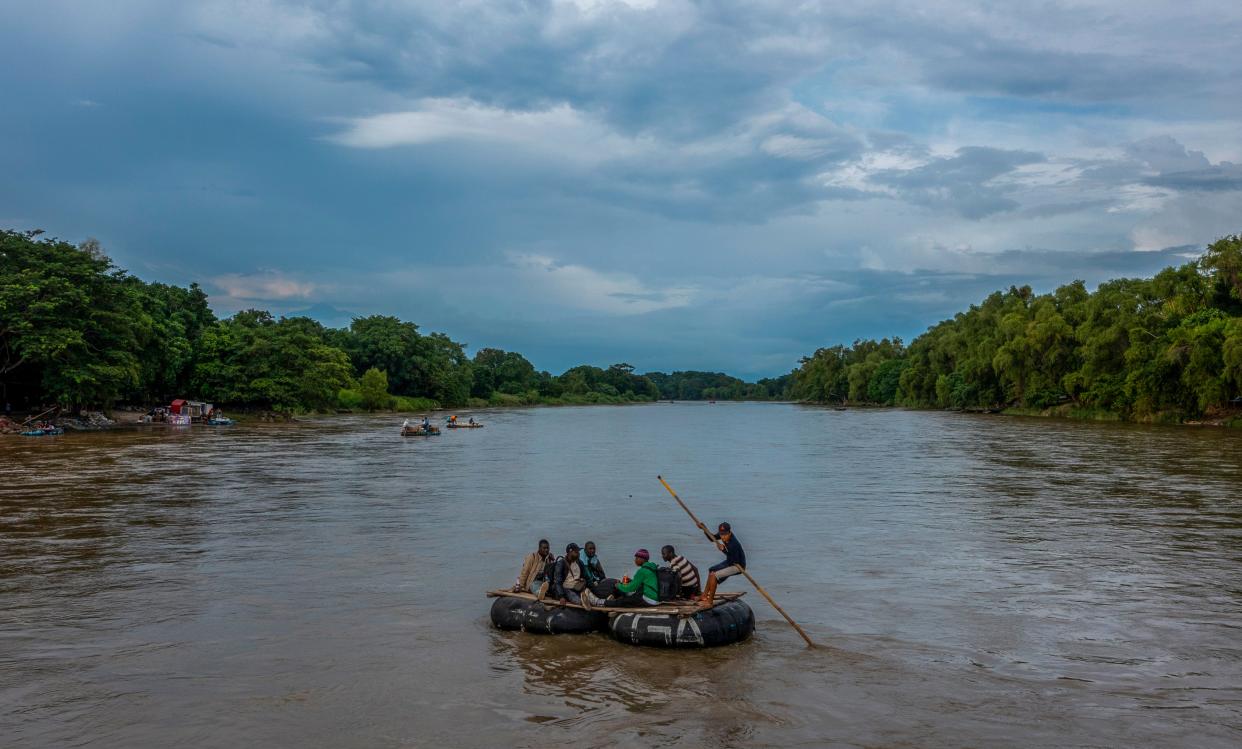 Migrants from Haiti cross the Suchiate River into Mexico from Guatemala on a raft as they make their way north to the U.S.-Mexico Border in October 2023.
