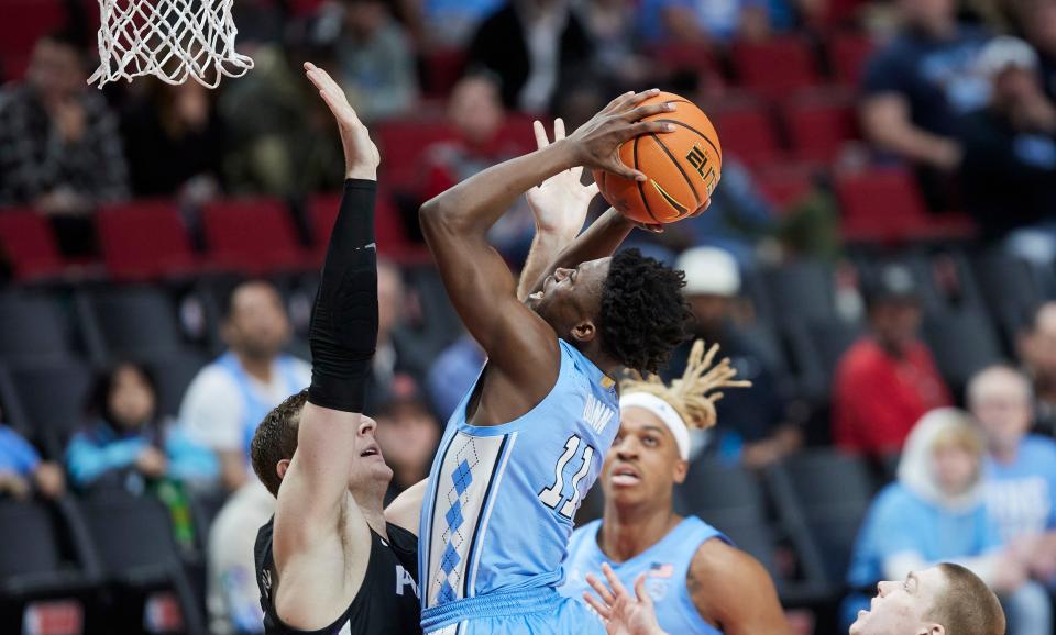 North Carolina guard D'Marco Dunn, right, shoots over Portland forward Moses Wood during the second half of an NCAA college basketball game in the Phil Knight Invitational tournament in Portland, Ore., Thursday, Nov. 24, 2022. (AP Photo/Craig Mitchelldyer)