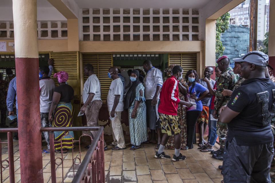 People line up to vote at the Boulbinet Deaf School in Conakry, Guinea, Sunday Oct. 18, 2020. Guinean President Alpha Conde is seeking to extend his decade in power, facing off against his longtime rival Cellou Dalein Diallo for the third time at the polls. (AP Photo/Sadak Souici)