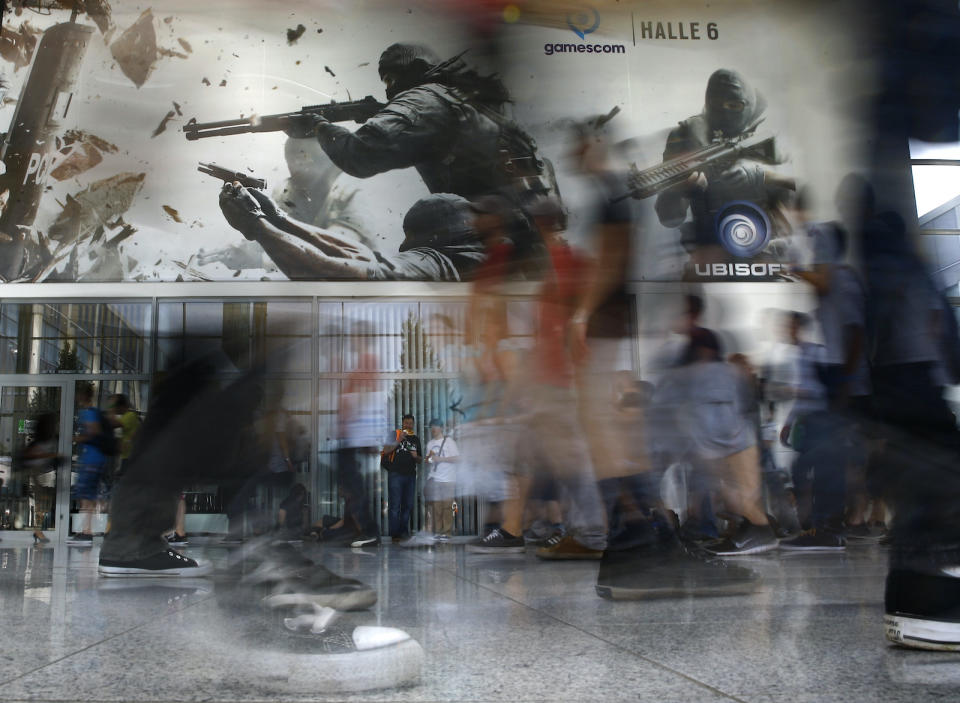 Visitors pass by a gaming booth of Ubisoft during the Gamescom fair in Cologne, Germany August 6, 2015. The Gamescom convention, Europe's largest video games trade fair, runs from August 5 to August 9. REUTERS/Kai Pfaffenbach TPX IMAGES OF THE DAY - LR2EB8612IC35