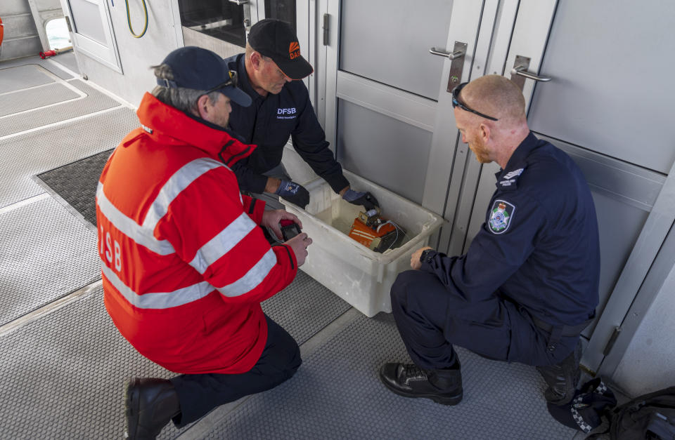 In this photo provided by the Australian Defense Force investigators prepare the recovered MRH-90 Taipan voice and flight data recorder for transport, at Whitsunday Islands, Australia on Monday, Aug. 7, 2023. Divers have recovered the flight data recorder from an Australia army helicopter that crashed at sea, killing the four crewmembers, during a military exercise with the United States last month, officials said Tuesday. (CPL Lisa Sherman/ADF via AP)
