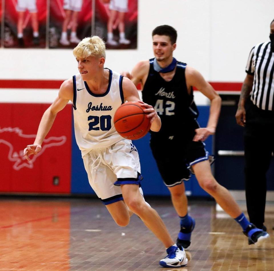 Joshua guard Brandon Ayars (20) drives down court ahead of North Forney center Gavin Sterling (42) during the second half of a 5A region 2 bi-district basketball game at Grapevine High School in Grapevine, Texas, Tuesday, Feb. 23, 2021. North Forney defeated Joshua 61-50. (Special to the Star-Telegram Bob Booth)