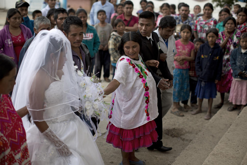 In this Tuesday, Feb. 11, 2014 photo, a Mixteco indigenous couple prepares to walk the steps into the church to get married in Cochoapa El Grande, Mexico. The head of Mexico’s anti-poverty program drew criticism Monday, May 5, 2014, after she warned Indian mothers that government aid programs would only help support their first three children. (AP Photo/Dario Lopez-Mills)